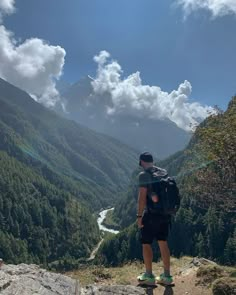 a man standing on top of a rock with a backpack