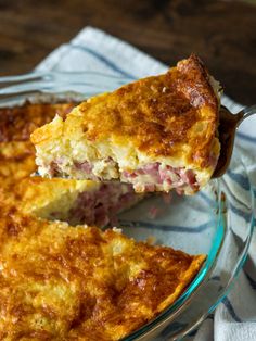 a piece of ham and cheese quiche on a glass plate with a serving spoon