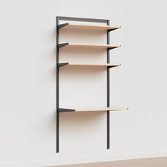 an empty book shelf in the corner of a room with white walls and wooden flooring