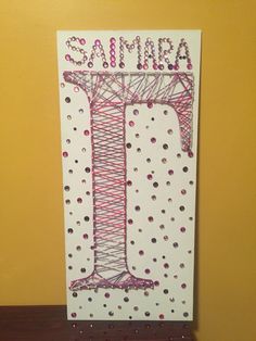 a handmade birthday card with the letter i in pink and purple thread on it