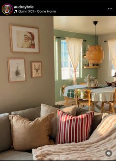 a living room filled with furniture and pictures hanging on the wall above it's windows