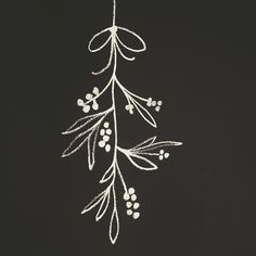 a white string hanging from the ceiling with berries and leaves drawn on it's side