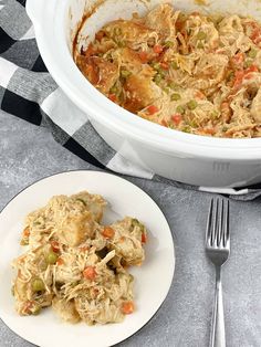 a white plate topped with food next to a casserole dish