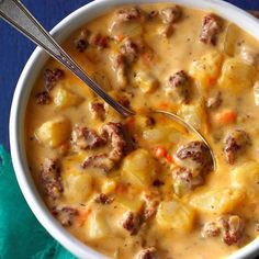 a bowl of soup with meatballs and cheese in it on a blue table cloth