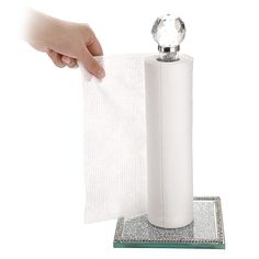 a person holding a roll of toilet paper in front of a white towel dispenser