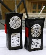 two black and red speakers sitting on top of a white cloth covered table next to each other