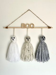 three mop hooks hanging on a wall with the word boo spelled in gold letters