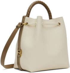 LWG-certified grained calfskin shoulder bag in beige and taupe. · Hand-wrapped carry handle · Adjustable crossbody strap · Logo stamp at face · Logo hardware at sides · Drawstring closure · Buffed lambskin lining · H9 x W11 x D6 Supplier color: Misty ivory Cream Calf Leather Bag With Gold-tone Hardware, Beige Calf Leather Shoulder Bag With Detachable Strap, Beige Calf Leather Bag With Dust Bag, Beige Calf Leather Crossbody Satchel, Cream Leather Bucket Bag With Top Handle, Cream Leather Bucket Bag With Top Carry Handle, Beige Calf Leather Satchel With Handle Drop, Beige Calf Leather Bag With Handle Drop, Beige Calf Leather Bag With Adjustable Strap