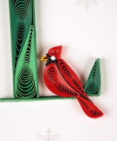 a red bird sitting on top of a piece of paper next to a green object