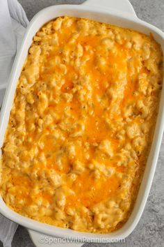 a casserole dish filled with macaroni and cheese on top of a napkin