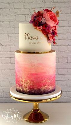 a three tiered cake with pink and purple ombreaches on the side