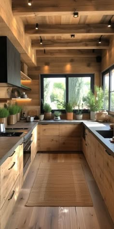 a kitchen with wooden walls and flooring next to a large window in the center