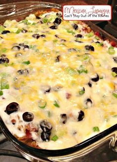 a casserole dish with black olives, green peppers and cheese on it