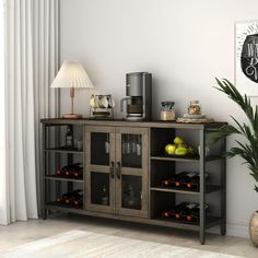 a living room with a potted plant next to a coffee maker on top of a wooden cabinet