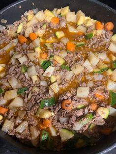 meat and vegetables cooking in a pan on the stove