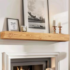 a fire place with candles and pictures on the mantle