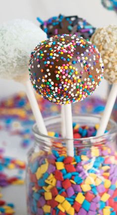 three cake pops with sprinkles in a jar