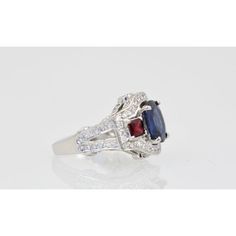 This is part of Chairish’s Fine Jewelry assortment.  Sapphire Ruby Diamond Ring 18K White Gold  This lovely Sapphire Ruby Diamond Ring is set in 14K White Gold. It features a Oval cut Sapphire weighing in at 2.67 Carats, flanked by 2 Rubys square cut and weighing 0.70 carats and White Diamonds, F-G, VS weighting in at 2.50 Carats. Set in a square shank mounting, measuring approximately 15mm tapering to 2.4mm Size 6.5. Total weight: 5.87 carats. I purchased this to go with many of my Tutti Frutti Formal Sapphire Ring With Cushion Diamond Cut, Formal Sapphire Ring With Cushion Cut, Fine Jewelry Sapphire Ring With Cushion Diamond Cut, Elegant Cushion Cut Gemstone With Center Stone, Elegant Cushion Cut Gemstones, Classic Multi-stone Sapphire Ring With Diamonds, Formal Fine Jewelry Sapphire Cushion Cut Ring, Luxury Asscher-cut Sapphire Ring With Diamond Details, Elegant Sapphire Multi-stone Cluster Ring