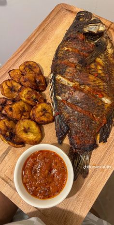 there is a large fish and some fried potatoes on the table next to it,