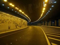 an empty road in the middle of a tunnel