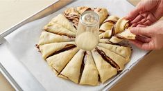 a person is spreading peanut butter on top of pastries with a bottle of caramel