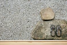 a pair of flip flops sitting on top of a rock next to a pair of sandals