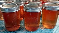 several jars filled with liquid sitting on top of a blue tablecloth covered table cloth