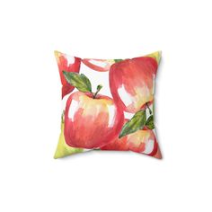 an apple pillow is shown on a white background, with green leaves and red apples