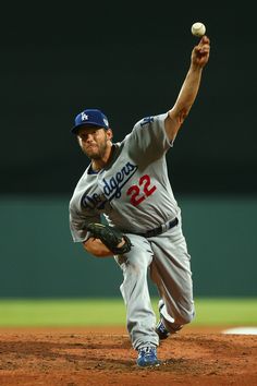 a baseball player throwing a ball on top of a field