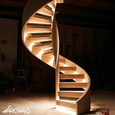 a spiral staircase lit up at night with lights on the bottom and inside it's sides