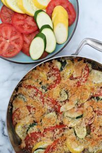 two pans filled with food sitting on top of a marble counter next to each other