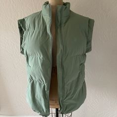 Collab Between Playboy And Pacsun. Featuring A Lightly Padded Body, This Sleeveless Vest Sports A Stand-Up Collar With A Full-Zipper Front Closure, Side Pockets, Subtle Playboy Graphic At The Left Chest, And An Oversized Fit. Size - Medium / Large Color - Sage Green Condition - Like New. Never Worn. No Tags. Material - She’ll: 59% Cotton, 41% Nylon, Lining: 100% Polyester Care - Machine Wash Cold Stock Photos Included For Style And Fit Reference Only. Truest Representation Of Color Is In My Own Brown Puffer, Oversized Vest, Womens Puffer Vest, Leather Halter, Fur Hoodie, Hoodie Vest, White Halter Maxi Dress, Leather Vest, Sleeveless Vest