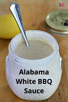 a jar filled with white sauce sitting on top of a wooden table