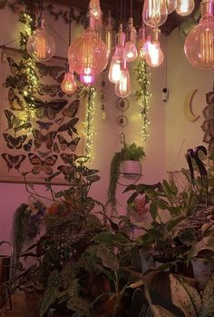 a room filled with lots of plants and hanging light bulbs above the ceiling covered in lights