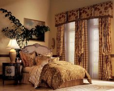 a large bed sitting in a bedroom next to a window covered in curtains and drapes