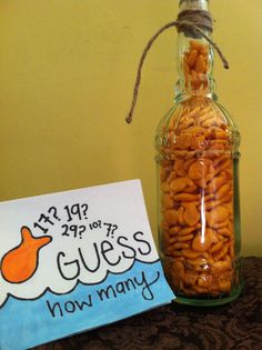 a glass bottle filled with peanuts sitting on top of a table next to a sign