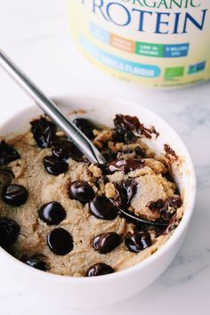 a bowl of oatmeal with chocolate chips and a bottle of organic protein