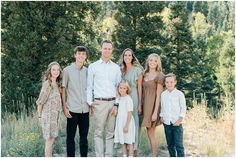 a family posing for a photo in front of some trees