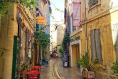 an alleyway with tables and chairs on the side