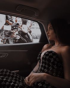 a woman sitting in the back seat of a car