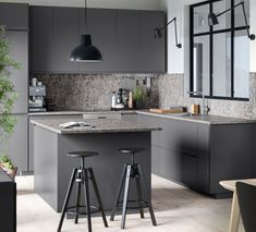 a kitchen with grey cabinets and stools