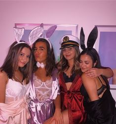 three girls in bunny ears and dresses posing for the camera with their arms around each other