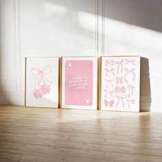 three pink and white greeting cards sitting on top of a wooden floor