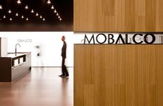 a man standing in front of a sign that says mobalco