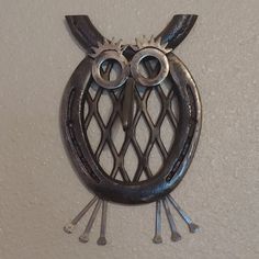 an owl shaped metal object hanging on the wall