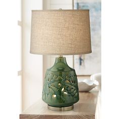 a green lamp sitting on top of a wooden table