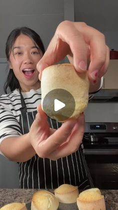 a woman in an apron is holding a roll and making some sort of bread with her hands