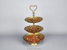 three tiered gold plate with hearts on each side and an orange bowl in the middle