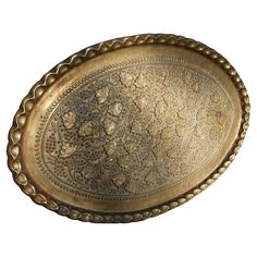 an ornately decorated brass tray on a white background