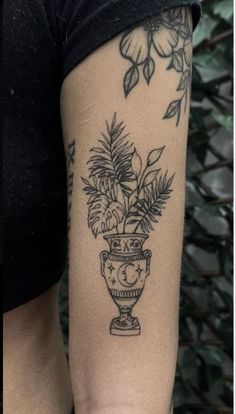 a woman's arm with a potted plant tattoo on the left side of her body